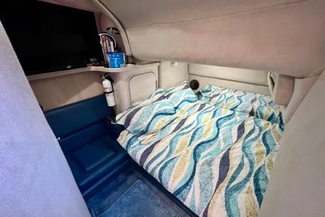 Slide: The Image of 1995 Regal Commodore 400 cabin interior with bed, fire extinguisher, and patterned bedding. - 12