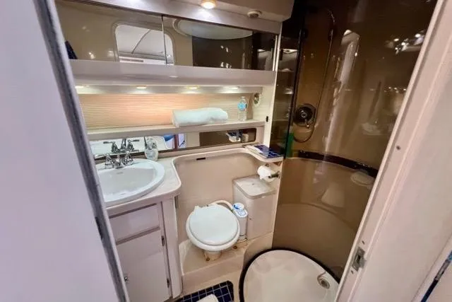Slide: The Image of Compact bathroom in a 1995 Regal Commodore 400 yacht, featuring sink, toilet, and shower. - 13