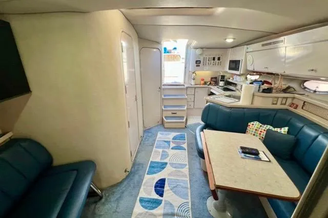 Slide: The Image of Interior of 1995 Regal Commodore 400 yacht with blue seating and modern kitchen area. - 5