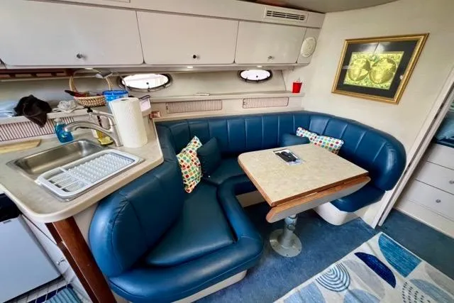 Slide: The Image of 1995 Regal Commodore 400 interior with blue seating, kitchenette, and dining area. - 7