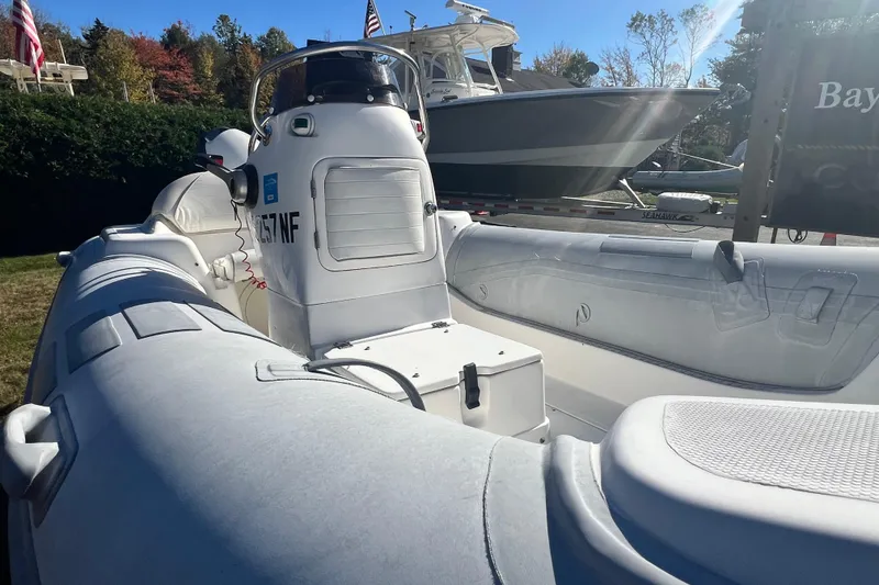 Slide: The Image of 2007 Caribe 15DL inflatable boat with console, docked outdoors on a sunny day. - 9