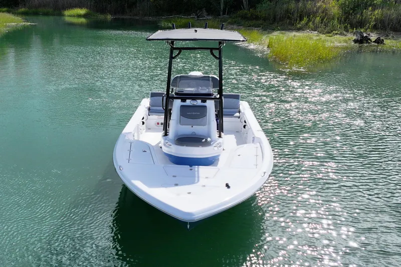 Slide: The Image of 2026 NauticStar 214 Bay boat on serene water, front view. - 10