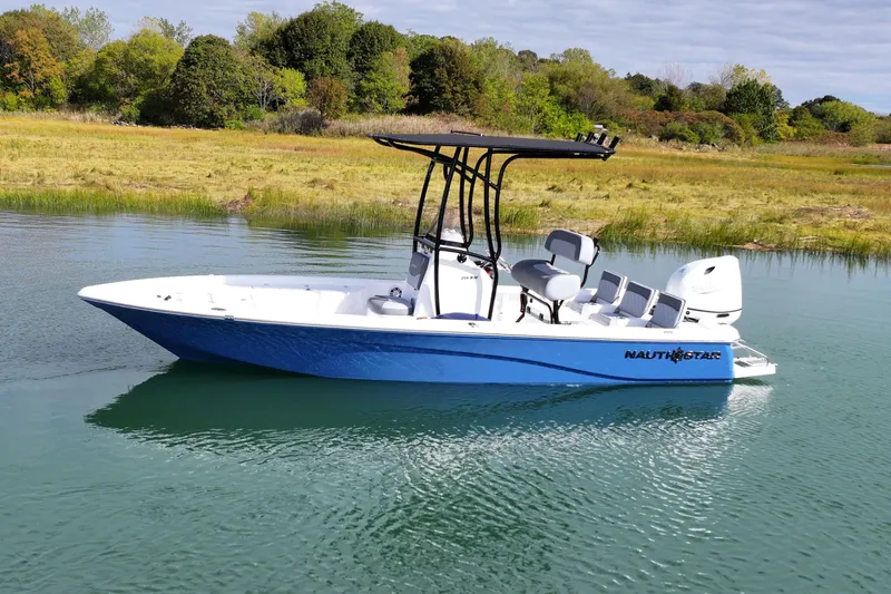 Slide: The Image of 2026 NauticStar 214 Bay boat on calm water, surrounded by lush greenery. - 8
