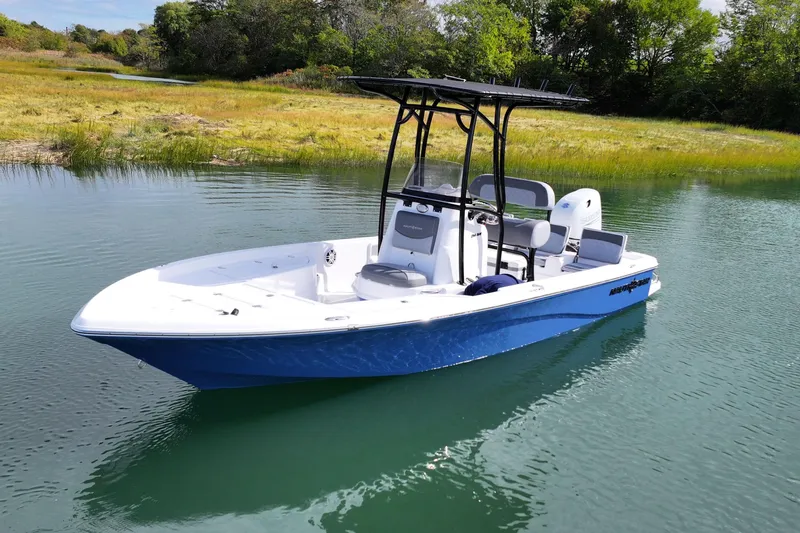 Slide: The Image of 2026 NauticStar 214 Bay boat on calm water, surrounded by lush greenery. - 9