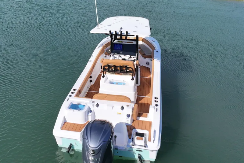 Slide: The Image of 2026 NauticStar 242 Offshore boat on calm water, showcasing spacious deck and modern design. - 13