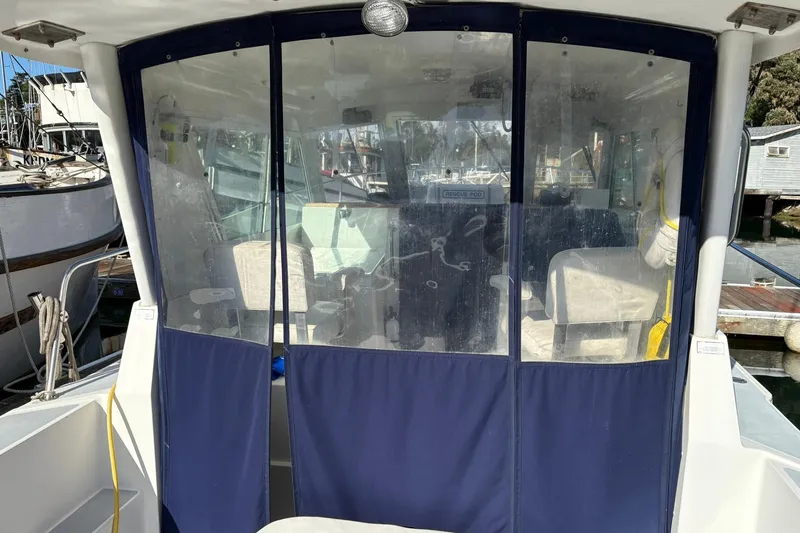 Slide: The Image of 2005 Albin 28 Tournament Express boat with blue canvas enclosure at a marina. - 15