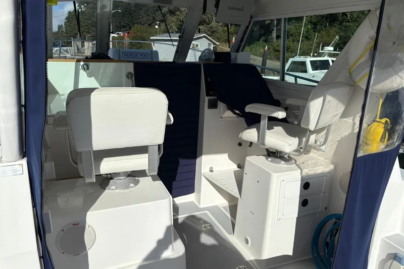 Slide: The Image of 2005 Albin 28 Tournament Express interior with white seating and navigation equipment. - 16