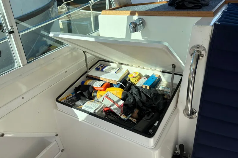 Slide: The Image of Storage compartment on a 2005 Albin 28 Tournament Express boat, filled with various supplies. - 18