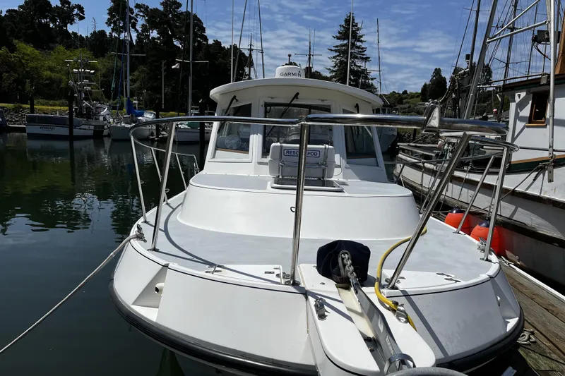 Slide: The Image of 2005 Albin 28 Tournament Express boat docked in a marina, surrounded by other vessels. - 2