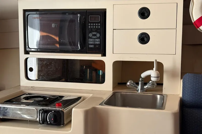 Slide: The Image of 2005 Albin 28 Tournament Express galley with microwave, stove, and sink. - 33