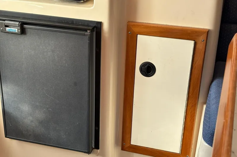 Slide: The Image of Interior of 2005 Albin 28 Tournament Express with fridge and wooden panel. - 34