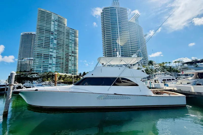 The Image of 2004 Viking 65 Convertible yacht docked near modern high-rise buildings. - 0