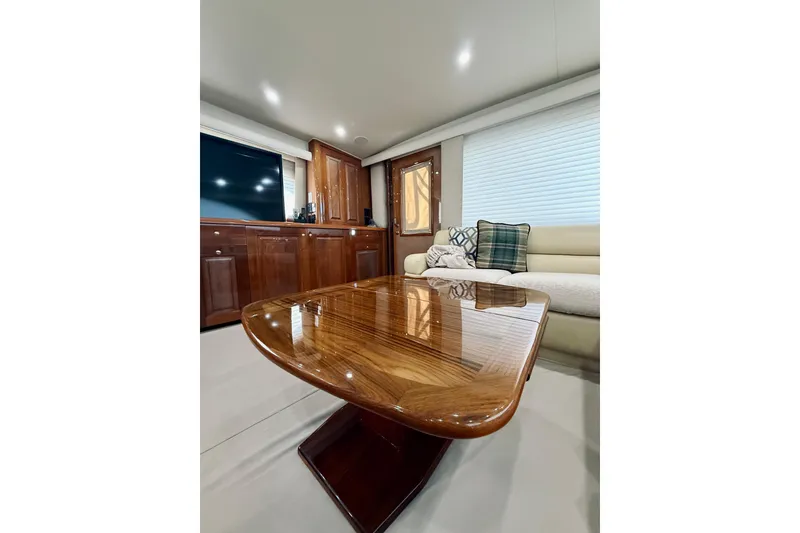 Slide: The Image of Luxurious interior of 2004 Viking 65 Convertible yacht with polished wood table and plush seating. - 17
