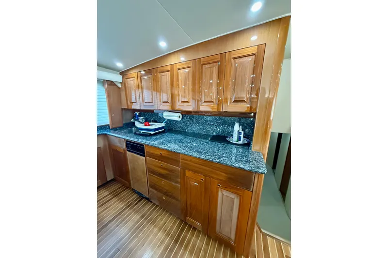 Slide: The Image of Luxurious kitchen interior of 2004 Viking 65 Convertible yacht with wooden cabinets and granite countertops. - 23