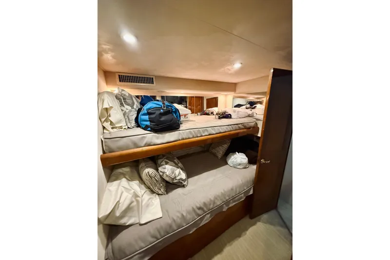Slide: The Image of 2004 Viking 65 Convertible yacht interior with bunk beds and luggage. - 26