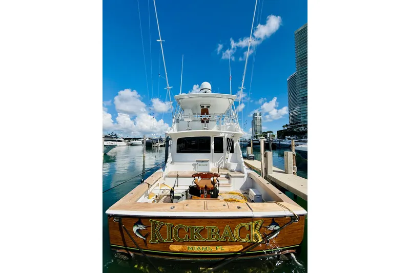 Slide: The Image of 2004 Viking 65 Convertible yacht "Kickback" docked in Miami marina under clear blue sky. - 3