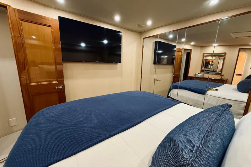 Slide: The Image of Luxurious bedroom interior of 2004 Viking 65 Convertible yacht with mirrored closet and TV. - 31