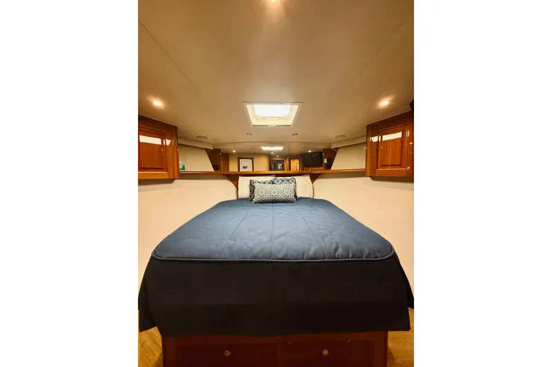 Slide: The Image of Luxurious cabin interior of 2004 Viking 65 Convertible yacht with cozy bed and wooden cabinets. - 37