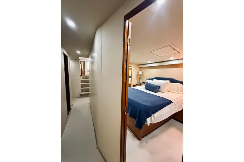 Slide: The Image of Interior of 2004 Viking 65 Convertible yacht featuring a cozy bedroom with blue bedding. - 38