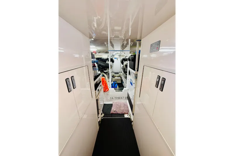 Slide: The Image of Engine room of 2004 Viking 65 Convertible yacht, featuring sleek white cabinetry and equipment. - 39
