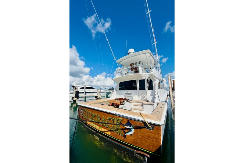 Slide: The Image of 2004 Viking 65 Convertible yacht docked under a clear blue sky. - 4