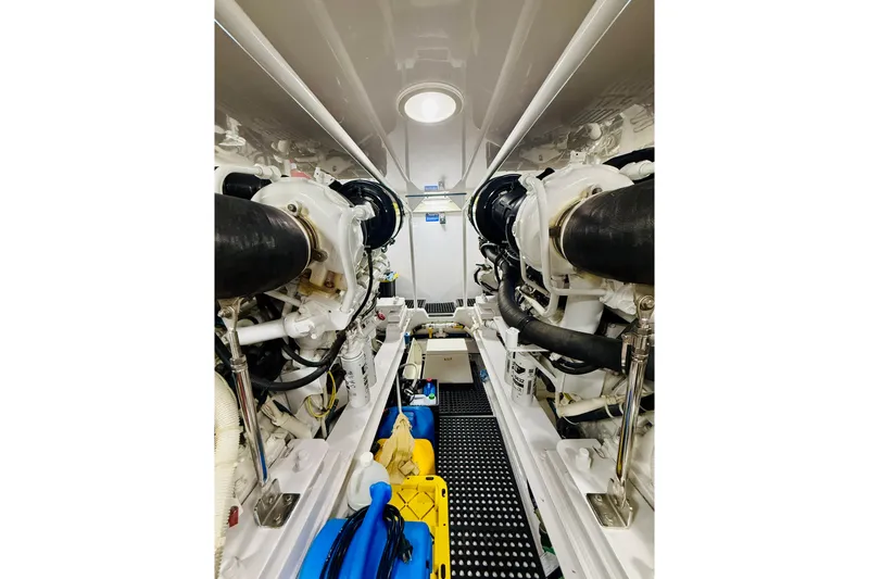 Slide: The Image of Engine room of a 2004 Viking 65 Convertible yacht, showcasing dual engines and mechanical components. - 43