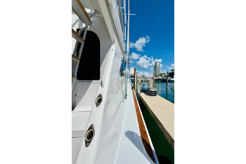 Slide: The Image of 2004 Viking 65 Convertible yacht docked at marina under clear blue sky. - 5