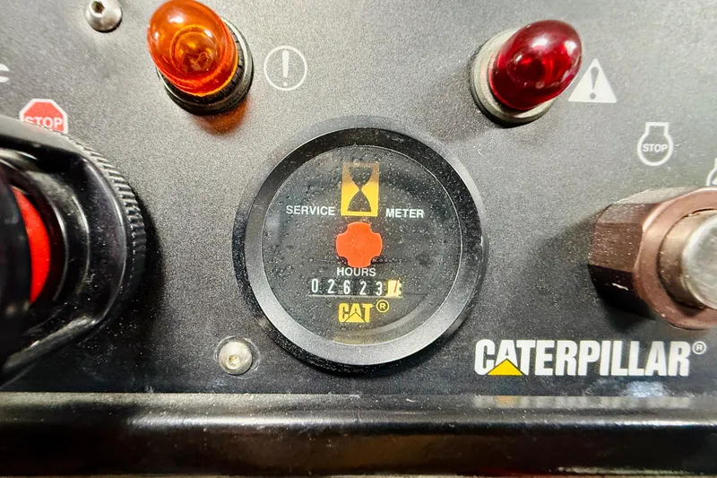 Slide: The Image of Caterpillar service meter displaying 2623 hours on a control panel with warning lights. - 50