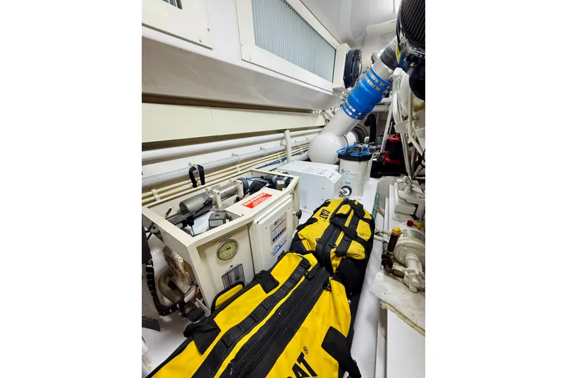 Slide: The Image of Engine room of 2004 Viking 65 Convertible yacht with equipment and yellow bags. - 57