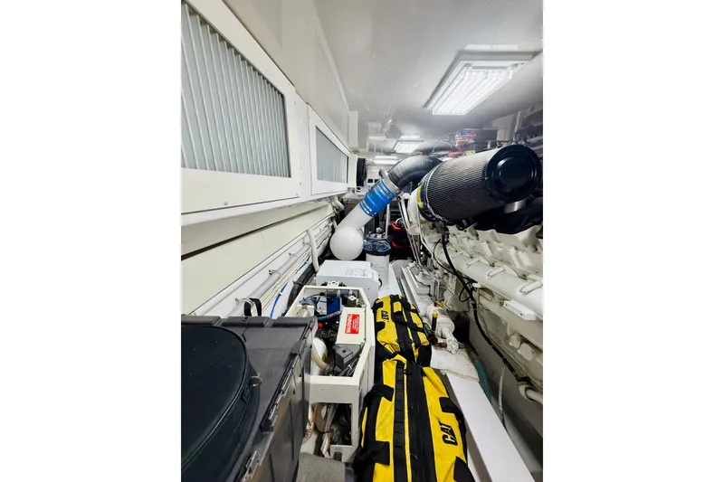 Slide: The Image of Engine room of 2004 Viking 65 Convertible yacht, featuring mechanical components and equipment. - 58