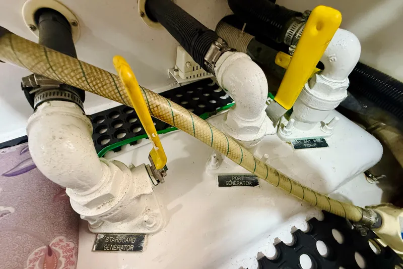 Slide: The Image of Engine room of 2004 Viking 65 Convertible with labeled generator valves and hoses. - 66