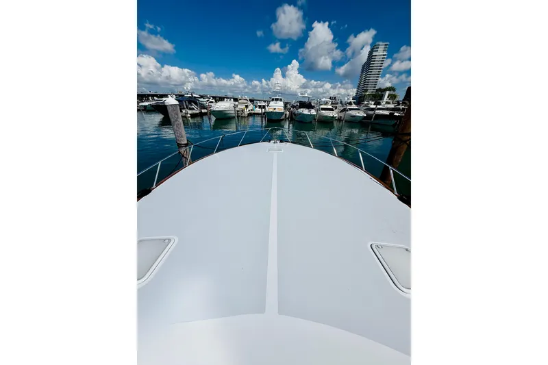 Slide: The Image of Bow view of 2004 Viking 65 Convertible yacht docked at marina under blue sky. - 7