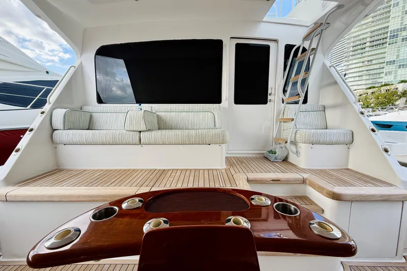 Slide: The Image of 2004 Viking 65 Convertible yacht interior with seating and wooden table. - 70