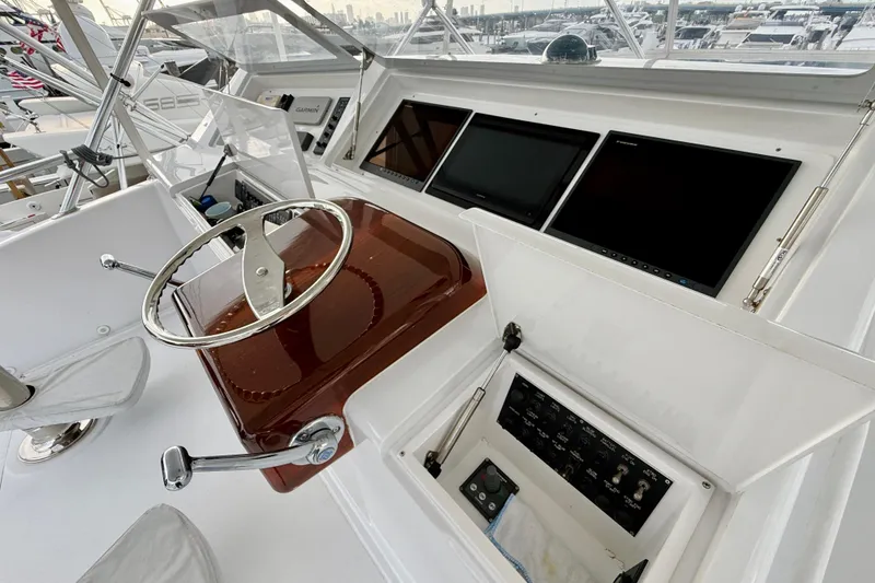 Slide: The Image of 2004 Viking 65 Convertible yacht helm with steering wheel and navigation screens. - 74