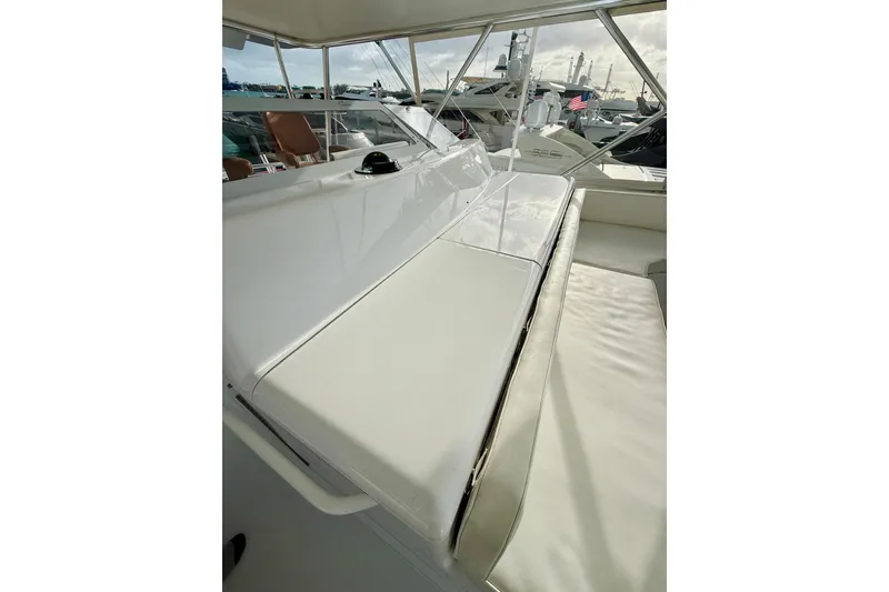 Slide: The Image of 2004 Viking 65 Convertible yacht interior with cushioned seating and helm view. - 77