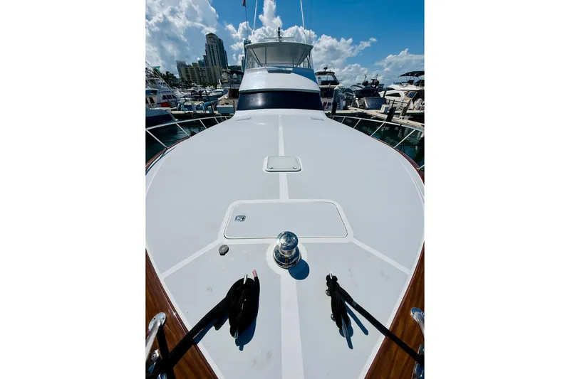 Slide: The Image of 2004 Viking 65 Convertible yacht docked at marina under blue sky. - 8
