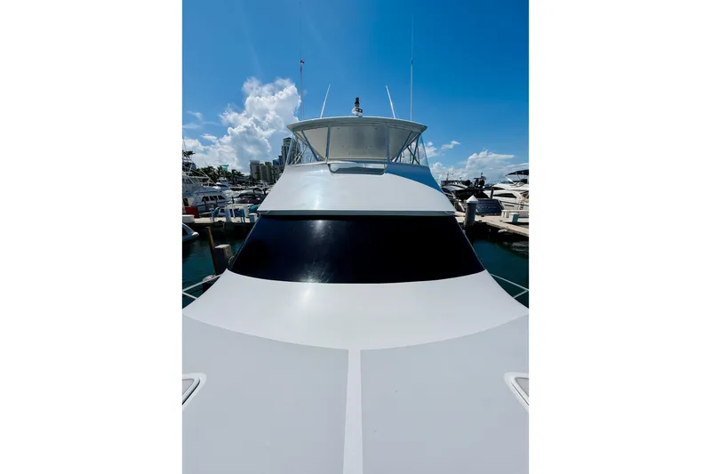 Slide: The Image of 2004 Viking 65 Convertible yacht docked under a clear blue sky. - 9
