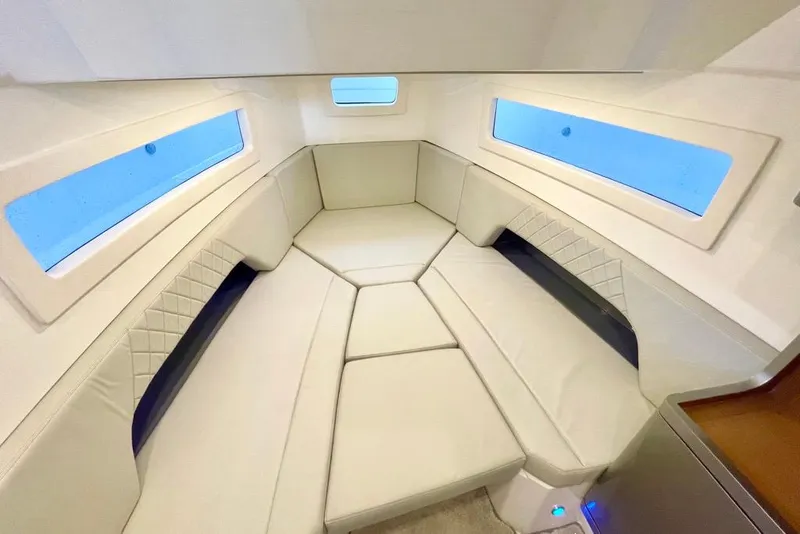 Slide: The Image of Open storage compartment of 2026 Schaefer V33 boat with visible blue hose. - 14