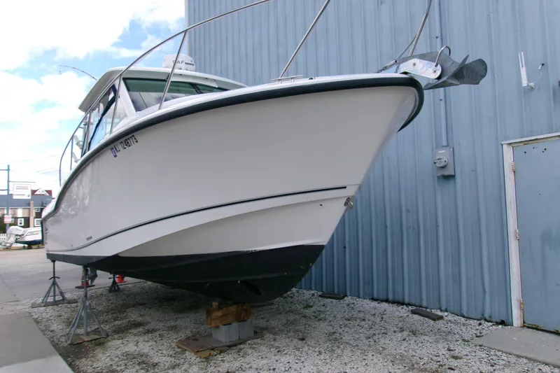 Slide: The Image of 2013 Boston Whaler 315 Conquest boat on dry dock near blue building. - 29