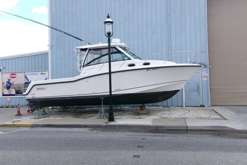 Slide: The Image of 2013 Boston Whaler 315 Conquest boat on dry dock near industrial building. - 30