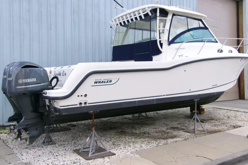 Slide: The Image of 2013 Boston Whaler 315 Conquest boat on stands, featuring Yamaha outboard motor. - 31