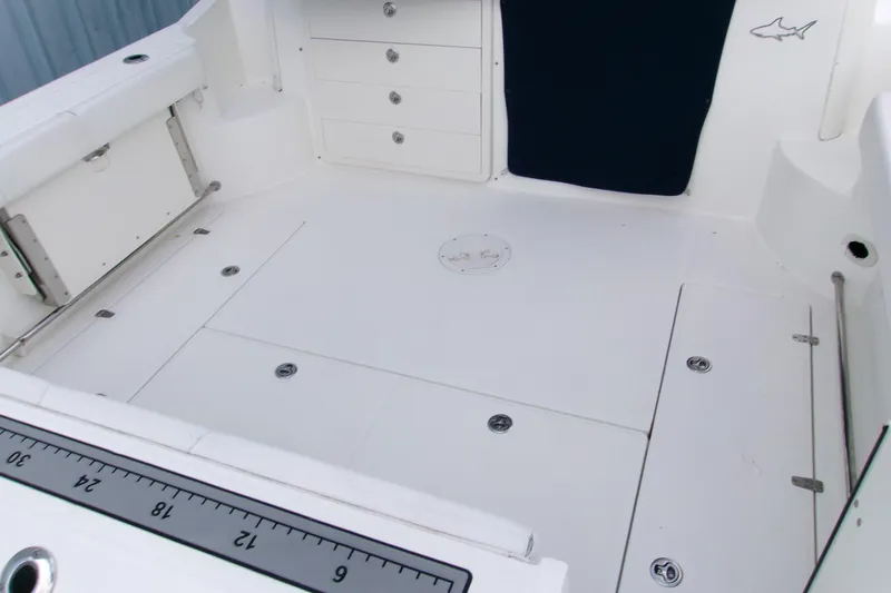 Slide: The Image of 2013 Boston Whaler 315 Conquest boat deck with storage compartments and measuring ruler. - 33