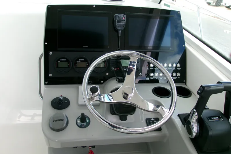 Slide: The Image of Control panel of 2013 Boston Whaler 315 Conquest boat with steering wheel and navigation screens. - 35