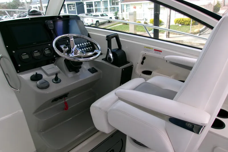 Slide: The Image of 2013 Boston Whaler 315 Conquest helm with steering wheel and control panel. - 36
