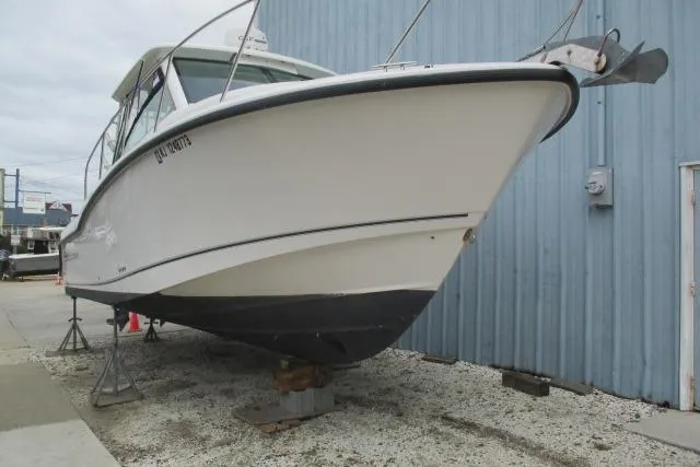 Slide: The Image of 2013 Boston Whaler 315 Conquest boat with Garmin equipment, docked near a street. - 9