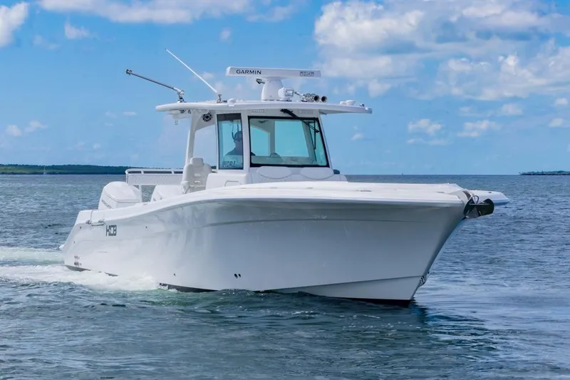 Slide: The Image of 2023 HCB 39 Speciale boat cruising on open water under a clear blue sky. - 1