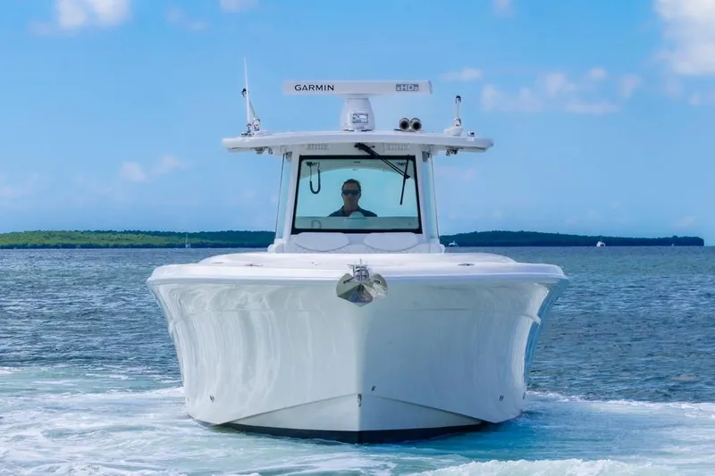 Slide: The Image of 2023 HCB 39 Speciale boat cruising on open water under clear blue sky. - 2