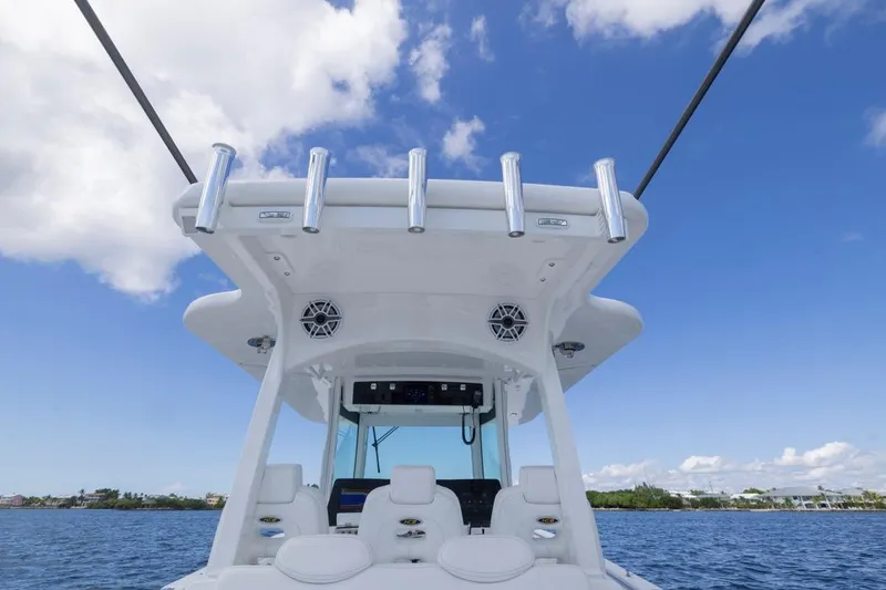 Slide: The Image of 2023 HCB 39 Speciale boat helm with rod holders, under a clear blue sky. - 38