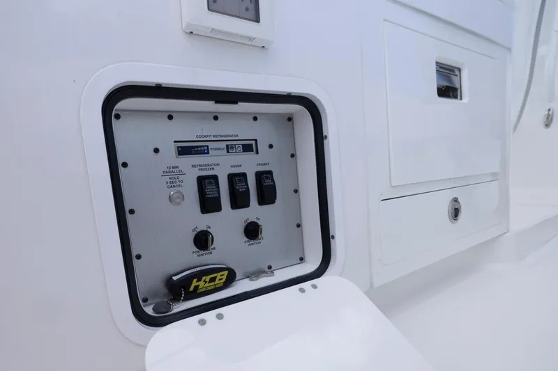 Slide: The Image of Control panel on 2023 HCB 39 Speciale boat, featuring switches and storage compartments. - 45