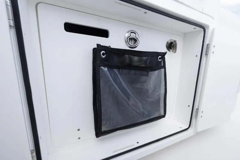 Slide: The Image of Storage compartment on 2023 HCB 39 Speciale boat, featuring a mesh pocket and secure latch. - 48